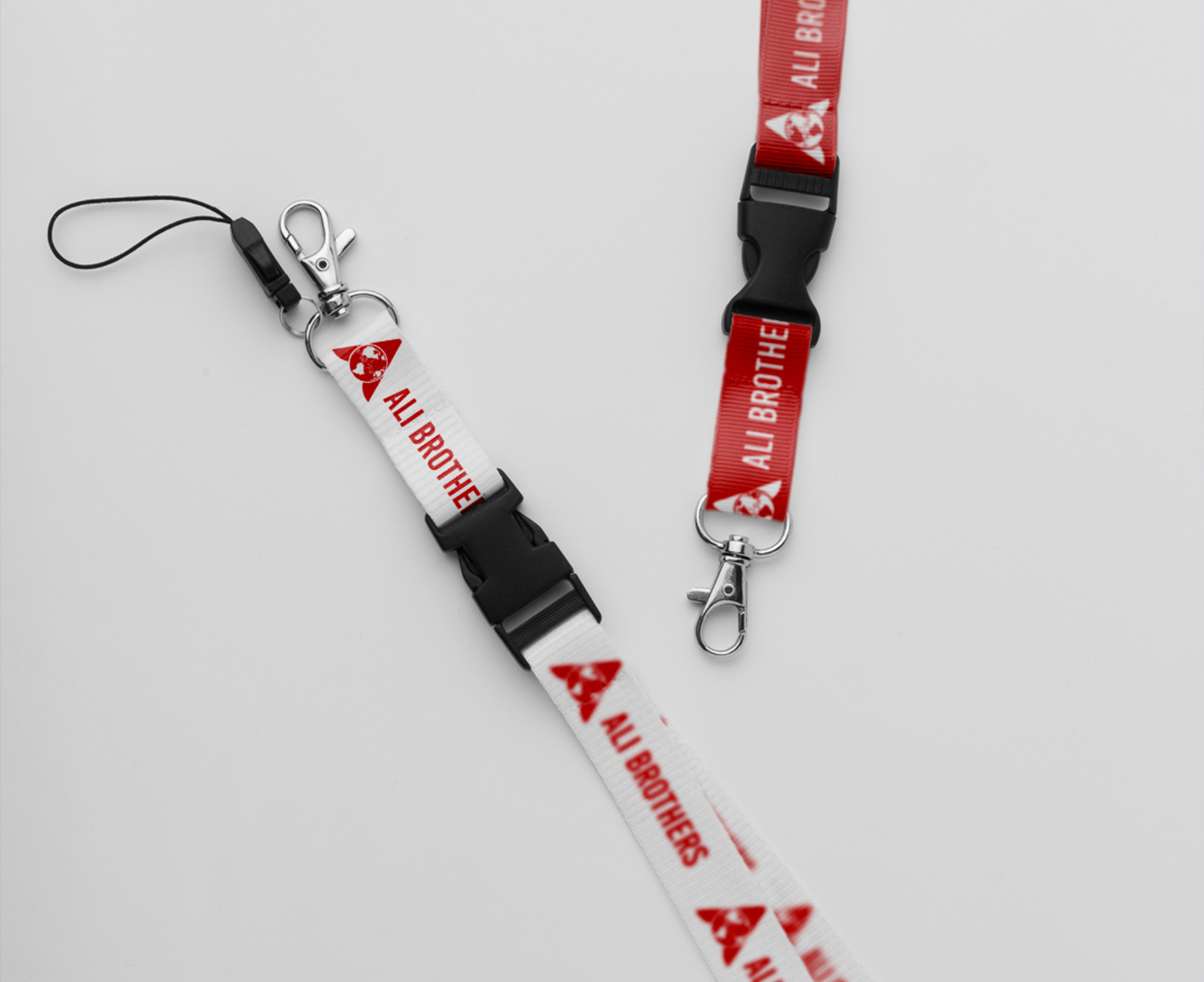 Ali Brothers red and white branded lanyards with clips and buckles.